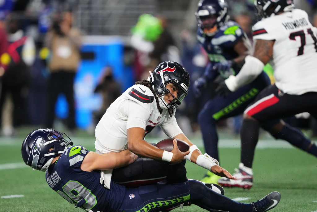 Houston Texans quarterback C.J. Stroud, top, is sacked by Seattle Seahawks safety Ty Okada (39) in the second half of an NFL football game Monday, Oct. 20, 2025, in Seattle. (AP Photo/Lindsey Wasson)