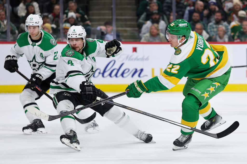 Minnesota Wild right wing Danila Yurov (22) shoots the puck as Dallas Stars defenseman Miro Heiskanen (4) defends during the second period of an NHL hockey game Thursday, Dec. 11, 2025, in St. Paul, Minn. (AP Photo/Matt Krohn)