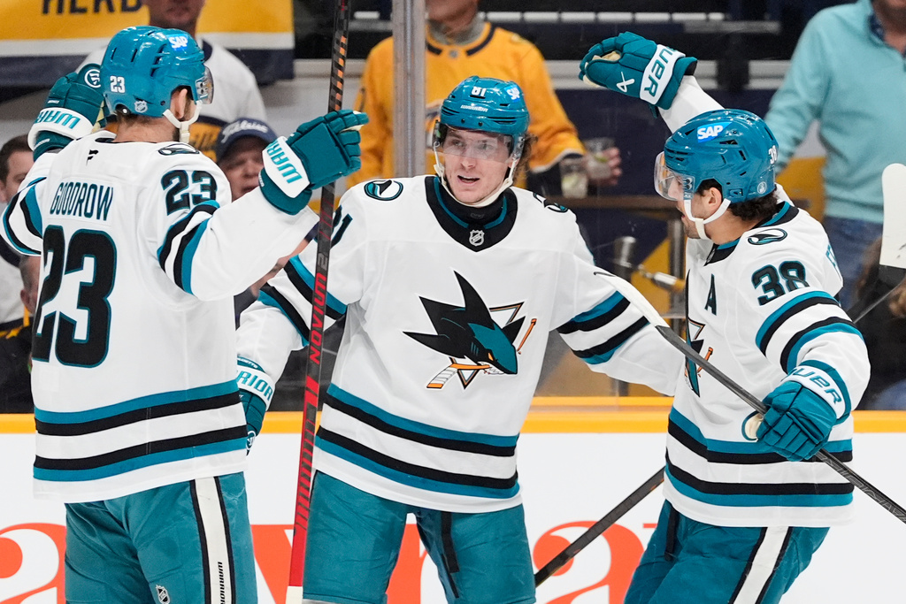 San Jose Sharks right wing Adam Gaudette (81) celebrates his goal with center Barclay Goodrow (23) and defenseman Mario Ferraro (38) during the first period of an NHL hockey game against the Nashville Predators, Tuesday, March 24, 2026, in Nashville, Tenn. (AP Photo/George Walker IV)