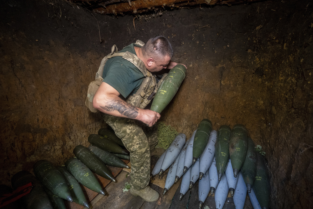 A soldier of Ukraine's 30th Mechanized Brigade prepares to fire a howitzer towards Russian positions on the front line near near Kharkiv, Ukraine, Wednesday, Aug. 13, 2025. (AP Photo/Andrii Marienko)
