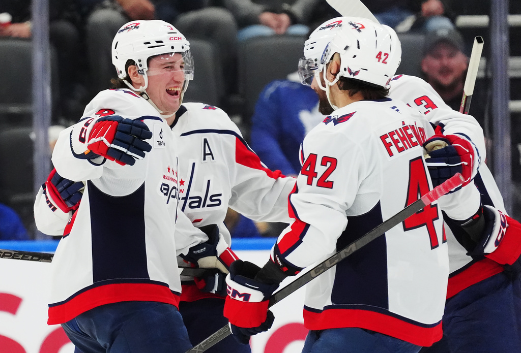 Washington Capitals' Ryan Leonard (left) and Martin Fehervary (42) celebrate a goal against the Toronto Maple Leafs with teammates during second period NHL hockey action in Toronto on Wednesday, April 8, 2026. (Frank Gunn/The Canadian Press via AP)