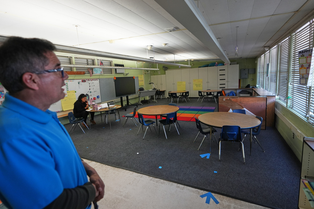 Principal Fernando Hernandez looks on in an empty classroom where a teacher is taking a lunch break at Perkins K-8 School Thursday, Nov. 13, 2025, in San Diego. (AP Photo/Gregory Bull)