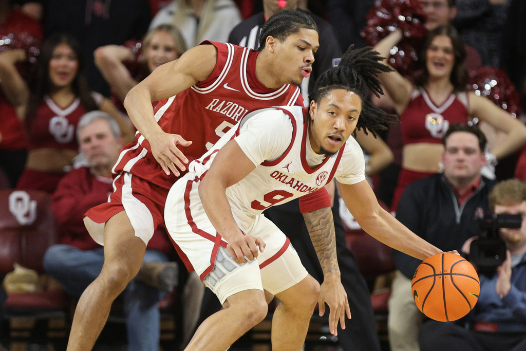 Oklahoma guard Nijel Pack, front, handles the ball against Arkansas guard Darius Acuff Jr., back, during the first half of an NCAA college basketball game Tuesday, Jan. 27, 2026, in Norman, Okla. (AP Photo/Nate Billings)