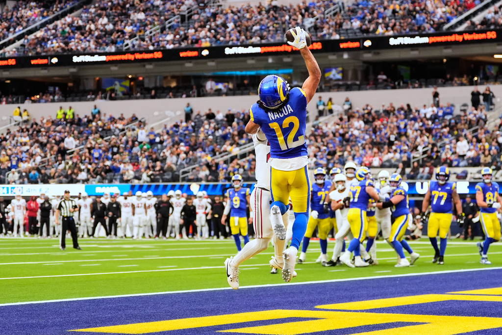 Los Angeles Rams wide receiver Puka Nacua (12) catches a touchdown while defended by Arizona Cardinals cornerback Denzel Burke (29) during the first half of an NFL football game, Sunday, Jan. 4, 2026, in Inglewood, Calif. (AP Photo/Mark J. Terrill)