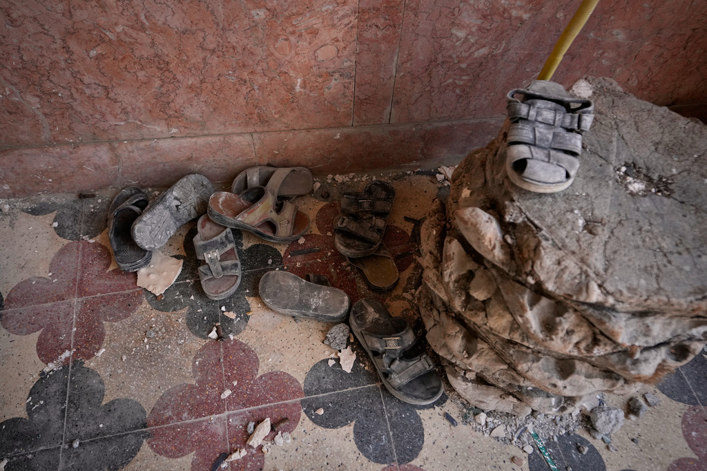 Dust-covered shoes lie amid debris inside a home that Iranian media said was hit by a U.S. strike while a wedding celebration was taking place late Tuesday, Sept. 1, in Kuhestak, southern Iran, Friday, Sept. 4, 2026. (AP Photo/Vahid Salemi)