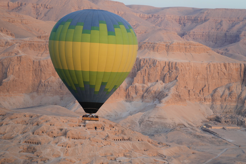 Tourists in a hot air balloon ride fly over the Valley of Kings in the southern city of Luxor, Egypt, Saturday, Oct. 4, 2025, where the tomb of Amenhotep III, who ruled ancient Egypt between 1390 B.C. and 1350 B.C., is opened to visitors for the first time in more than two decades. (AP Photo/Amr Nabil)