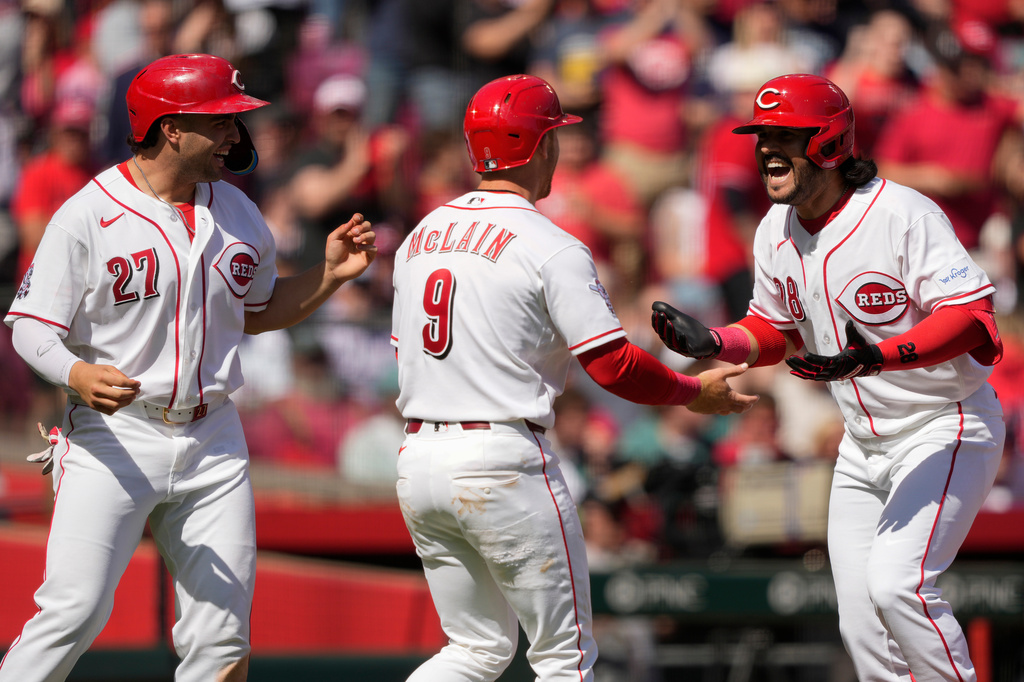 Cincinnati Reds' Eugenio Suárez (28), celebrates with Matt McLain (9) and Sal Stewart (27) after hitting a three-run homer during the sixth inning of a baseball game against the Boston Red Sox in Cincinnati, Sunday, March 29, 2026. (AP Photo/Carolyn Kaster)