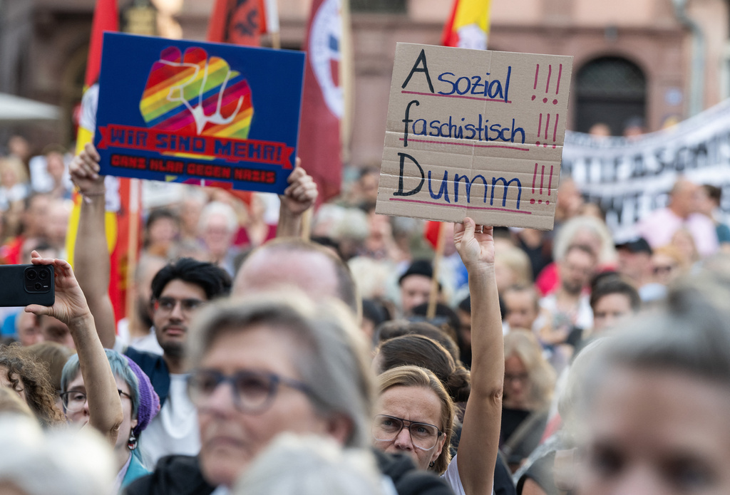 After the projections for the state election in Saxony-Anhalt were released, members of various coalitions protested against the AfD on the Römer, holding a sign that read "Anti-social, fascist, stupid!!!", in Frankfurt, Germany, Sunday, Sept. 6, 2026. (Boris Roessler/dpa via AP)
