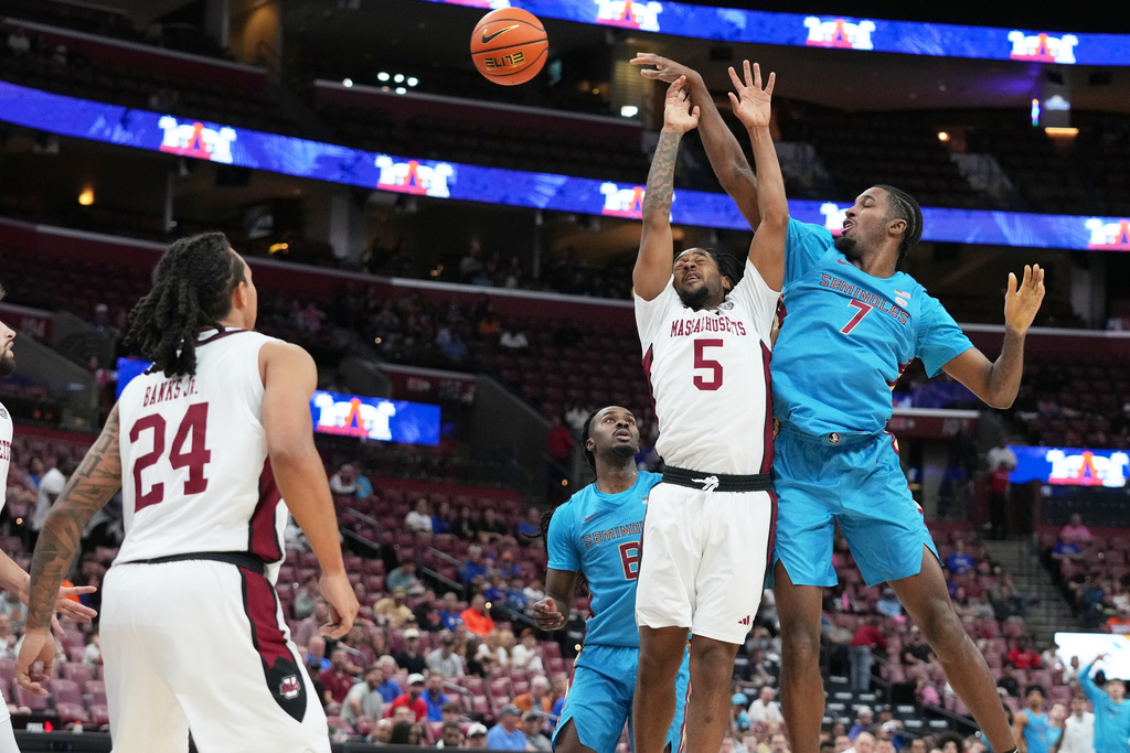 Florida State forward Chauncey Wiggins (7) passes the ball as Massachusetts guard K'Jei Parker (5) defends during the first half of an NCAA college basketball game at the Orange Bowl Basketball Classic, Saturday, Dec. 13, 2025, in Sunrise, Fla. (AP Photo/Lynne Sladky)