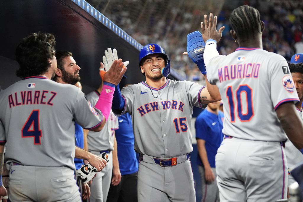 New York Mets' Tyrone Taylor (15) is congratulated after scoring on a walk by Juan Soto during the ninth inning of a baseball game against the Miami Marlins, Saturday, Sept. 27, 2025, in Miami. (AP Photo/Lynne Sladky)