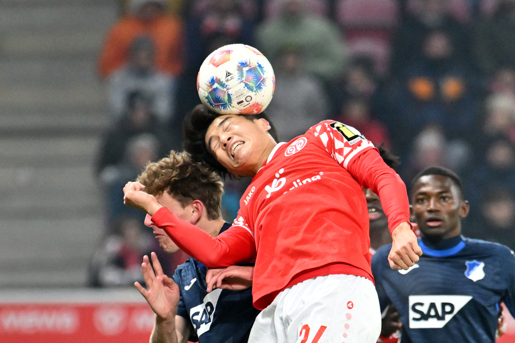 Mainz's Sota Kawasaki, right, heads the ball over Hoffenheim's Wouter Burger during the German Bundesliga soccer match between FSV Mainz 05 and TSG 1899 Hoffenheim in Mainz, Germany, Friday, Nov. 21, 2025. (Torsten Silz/dpa via AP)