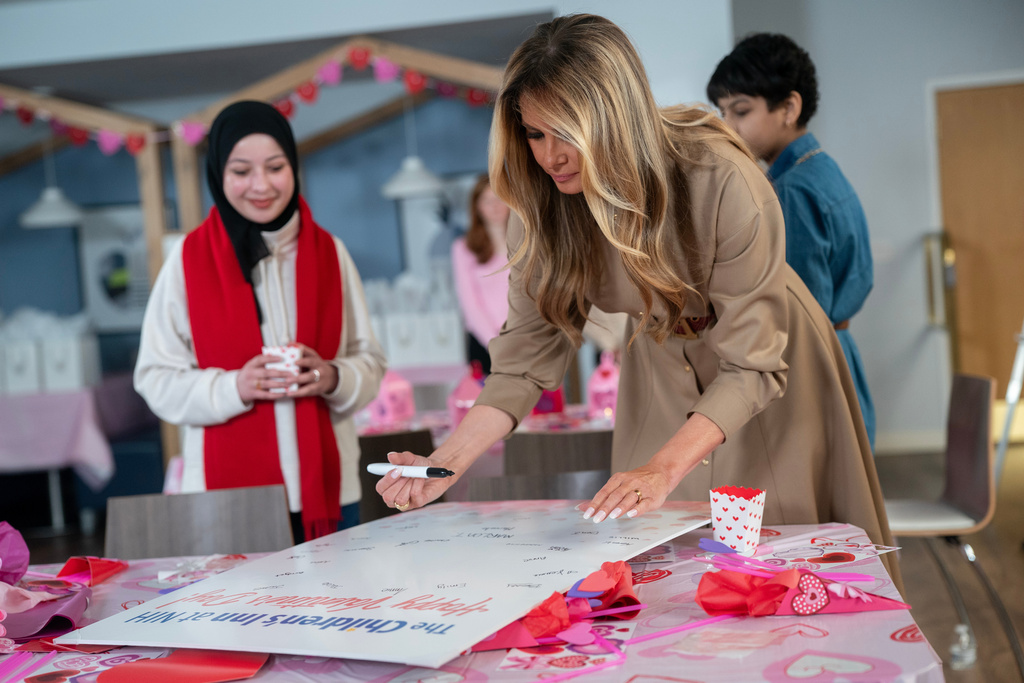 First lady Melania Trump signs a Valentine's Day card while working on arts and crafts with patients at The Children's Inn at the National Institutes of Health (NIH) in Bethesda, Md., Wednesday, Feb. 11, 2026. (AP Photo/Nathan Howard)