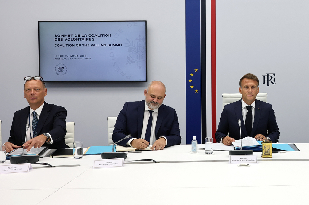 French President Emmanuel Macron, flanked by Elysee advisor Emmanuel Bonne, left, and Elysee's secretary-general Pierre-Andre Imbert, center, co-chairs a video conference meeting of the so-called Coalition of the Willing group of pro-Ukrainian countries, alongside British Prime Minister Andy Burnham and German Chancellor Friedrich Merz, and in presence of Ukrainian President Volodymyr Zelenskyy, to mark the 35th anniversary of Ukraine's independence, at the Elysee Palace in Paris, France, Monday, Aug. 24, 2026. (Stephanie Lecocq/Pool Photo via AP)