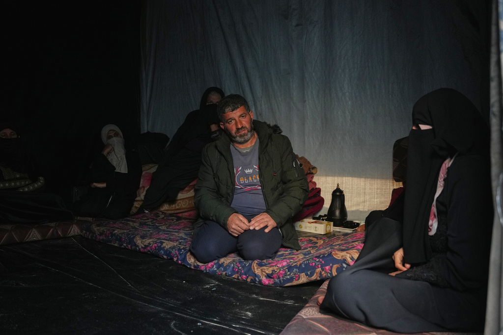 Eseid Abdeen, 42, the father of the 29-day-old infant, Saeed, who, according to health authorities, died due to the cold weather, sits in his tent while receiving condolences from family members and friends in a temporary camp for displaced Palestinians in Khan Younis, southern Gaza Strip, on Thursday, Dec. 18, 2025. (AP Photo/Abdel Kareem Hana)