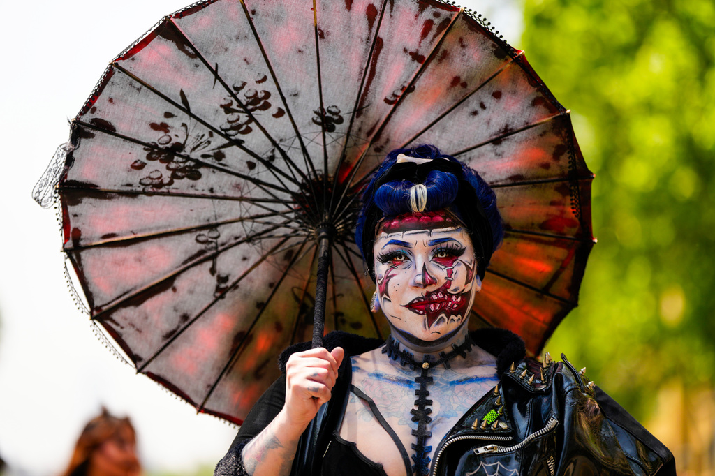 A woman eyes the camera while taking part in the Zombie Walk Retro 2026, a time-travel-themed march featuring costumes inspired by monsters and bygone eras, in Santiago, Chile, Saturday, Oct. 17, 2026. (AP Photo/Esteban Felix)
