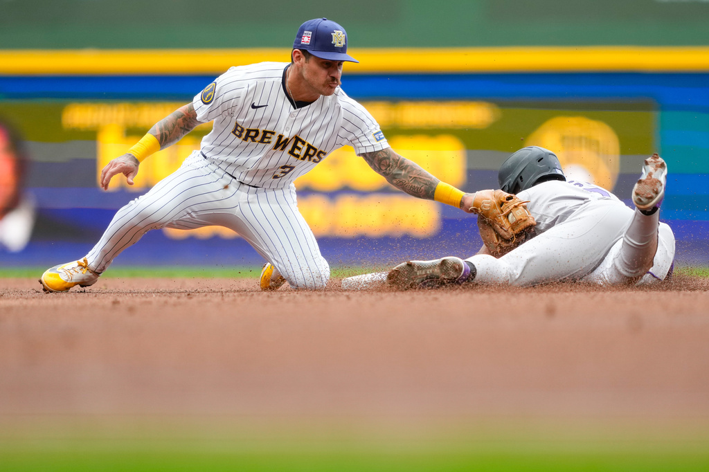Colorado Rockies' Willi Castro, right, steals second base as Milwaukee Brewers shortstop Joey Ortiz, left, is late with the tag during the fourth inning of a baseball game Friday, July 24, 2026, in Milwaukee. (AP Photo/Kayla Wolf) CORRECTION: Corrects to Rockies' Willi Castro steals second base not Rockies' Kyle Karros is tagged out.