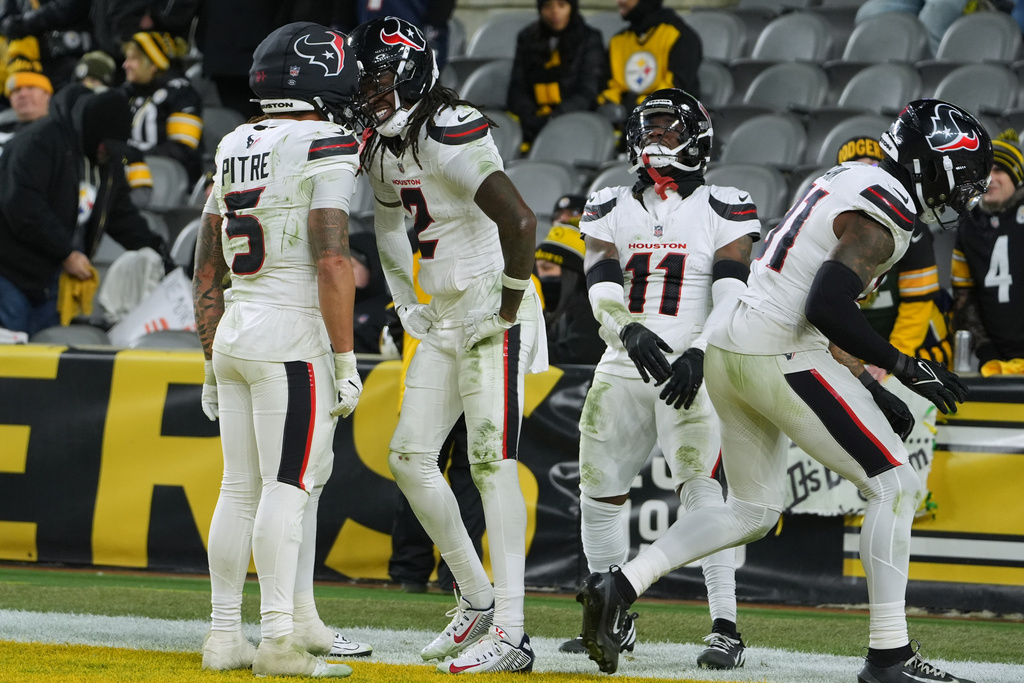 Houston Texans safety Calen Bullock (2) celebrates with safety Jalen Pitre (5) after running back an interception for a touchdown during the second half of NFL wild-card playoff football game against the Pittsburgh Steelers, Monday, Jan. 12, 2026, in Pittsburgh. (AP Photo/Gene J. Puskar)