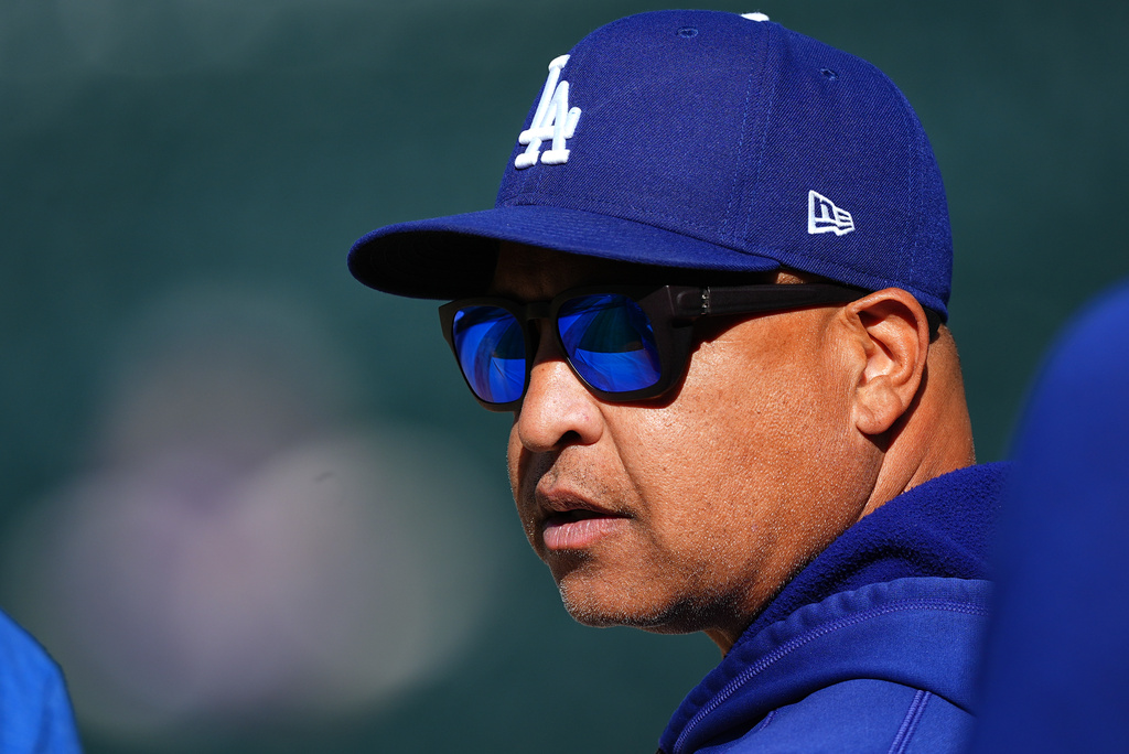 Los Angeles Dodgers manager Dave Roberts looks on as players warm up before a baseball game against the Colorado Rockies, Monday, Aug. 17, 2026, in Denver. (AP Photo/David Zalubowski)