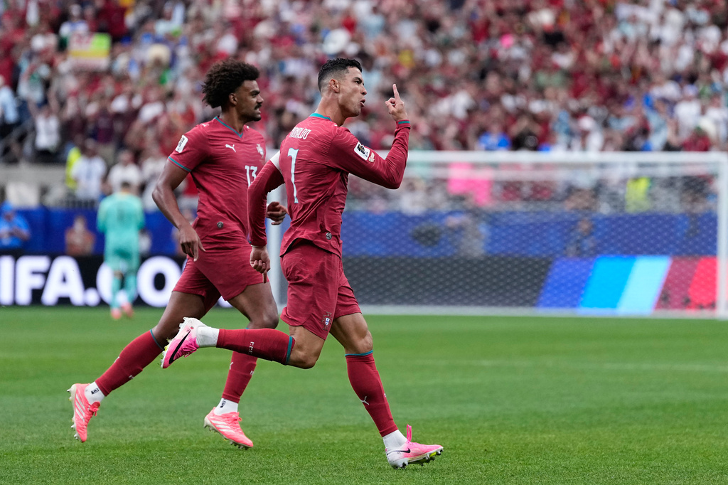 Portugal's Cristiano Ronaldo, right, celebrates after scoring the opening goal during the World Cup Group K soccer match between Portugal and Uzbekistan in Houston, Tuesday, June 23, 2026. (AP Photo/Ashley Landis)