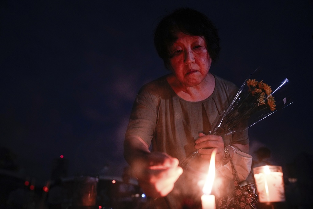 A visitor lights incense sticks at the Peace Memorial Park ahead of the memorial service to mark the 80th anniversary of the WWII U.S. atomic bombing in Hiroshima, Wednesday, Aug. 6, 2025, in Japan. (AP Photo/Louise Delmotte)