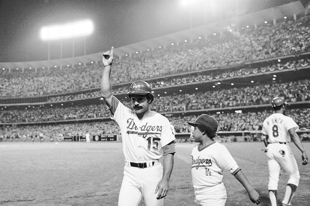 Los Angeles Dodgers Davey Lopes (15) signals to the crowd as he heads to the dugout on Tuesday, Oct. 10, 1978 in Los Angeles after hitting his second two-run home in the first game of the World Series. Youngster at right is Reggie Smith Jr. (AP Photo)
