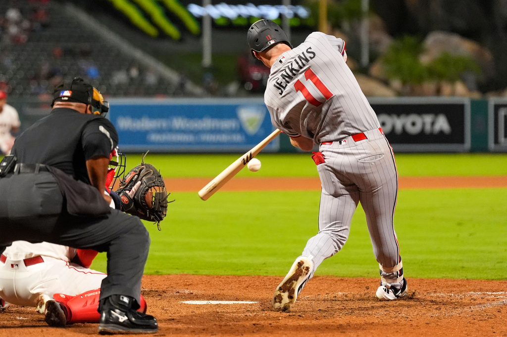 Minnesota Twins' Walker Jenkins, right, hits a two-run home run as Los Angeles Angels catcher Tyler Heineman, center, and home plate umpire Laz Diaz watch during the ninth inning of a baseball game Thursday, Sept. 17, 2026, in Anaheim, Calif. (AP Photo/Mark J. Terrill)
