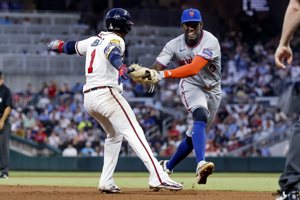 New York Mets shortstop Ronny Mauricio, right, tags out Atlanta Braves' Ozzie Albies, left, between second base and third during the fifth inning of a baseball game, Monday, July 6, 2026, in Atlanta. (AP Photo/Erik S. Lesser)