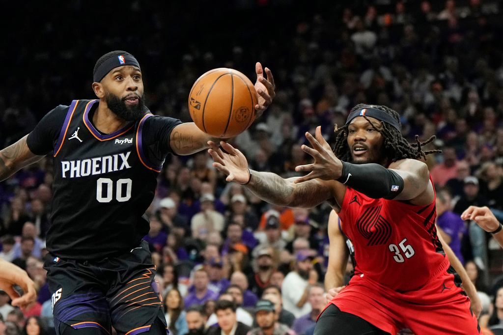 Phoenix Suns forward Royce O'Neale (00) gets the loose ball before Portland Trail Blazers center Robert Williams III (35) during the first half of an NBA play-in tournament basketball game, Tuesday, April 14, 2026, in Phoenix. (AP Photo/Ross D. Franklin)