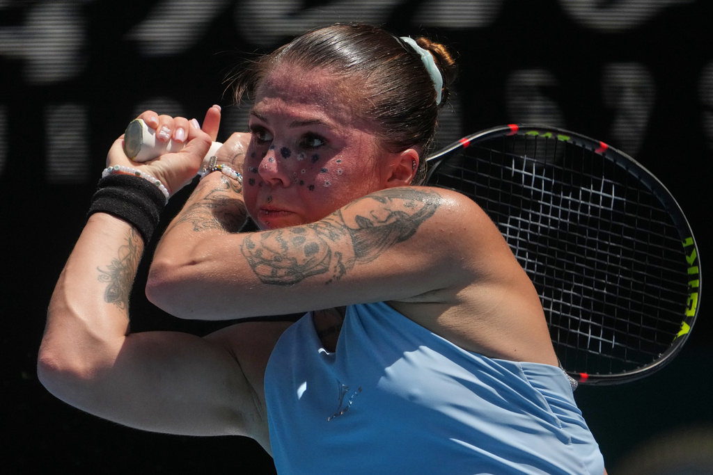 Oleksandra Oliynykova of Ukraine plays a backhand return to Madison Keys of the U.S. during their first round match at the Australian Open tennis championship in Melbourne, Australia, Tuesday, Jan. 20, 2026. (AP Photo/Asanka Brendon Ratnayake)