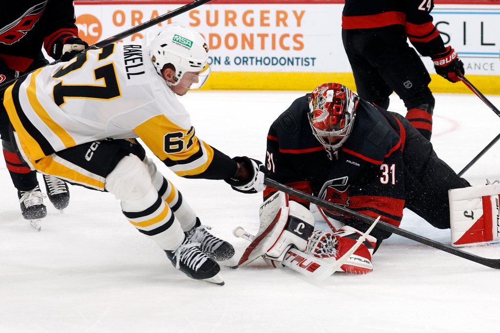 Carolina Hurricanes goaltender Frederik Andersen (31) covers the puck in front of Pittsburgh Penguins' Rickard Rakell (67) during the first period of an NHL hockey game in Raleigh, N.C., Tuesday, March 10, 2026. (AP Photo/Karl DeBlaker)