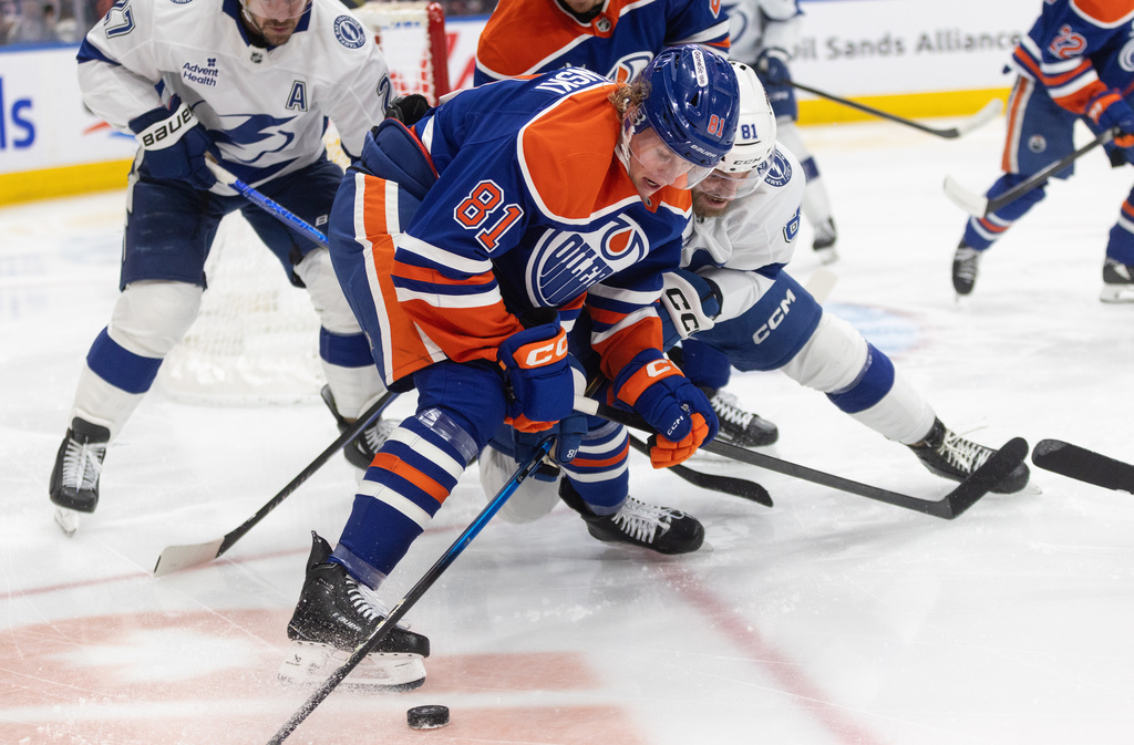 Tampa Bay Lightning's Erik Cernak (front) and Edmonton Oilers' Josh Samanski battle for the puck during second period NHL action, in Edmonton on Saturday March 21, 2026. (Jason Franson/The Canadian Press via AP)
