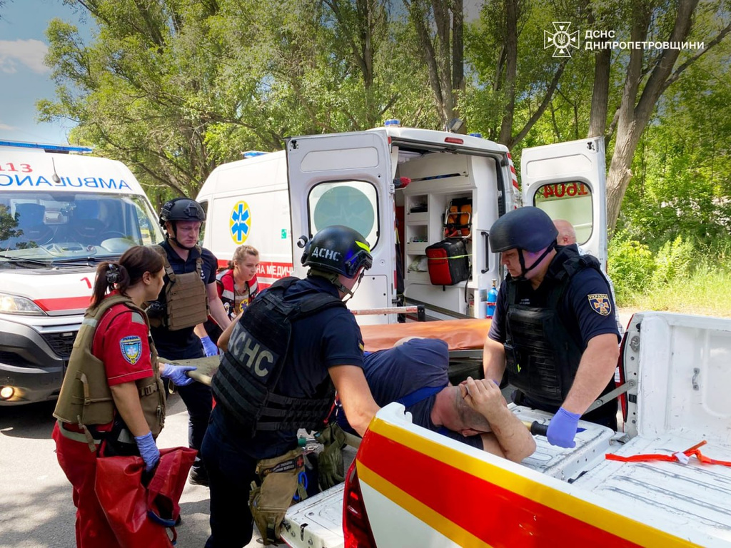 In this photo provided by the Ukrainian Emergency Services on Monday, June 29, 2026, a rescue worker with paramedics move an injured man into an ambulance after a Russian drone strike on passengers minivan in Dnipropetrovsk region, Ukraine. (Ukrainian Emergency Service via AP)