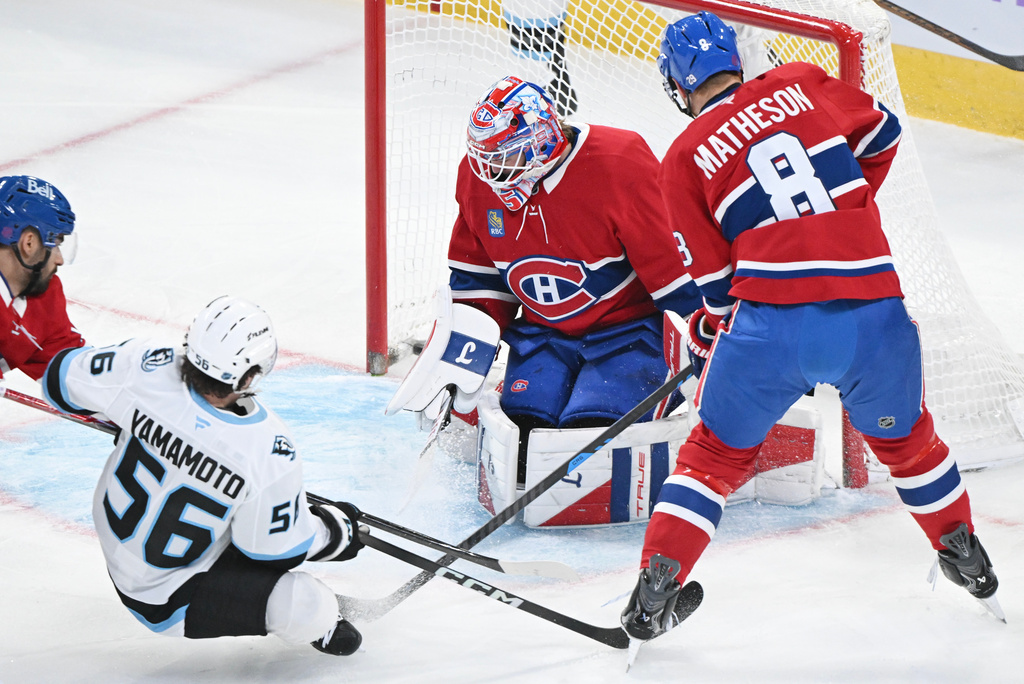 Utah Mammoth's Kailer Yamamoto (56) scores against Montreal Canadiens goaltender Sam Montembeault as Canadiens' Mike Matheson (8) defends during first period NHL hockey action in Montreal, Saturday, Nov. 8, 2025. (Graham Hughes/The Canadian Press via AP)
