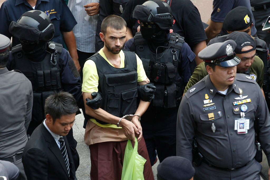 FILE - Police officers escort Bilal Mohammad, center, during a reenactment at Erawan Shrine in Bangkok, on Sept. 26, 2015. (AP Photo/Sakchai Lalit, File)