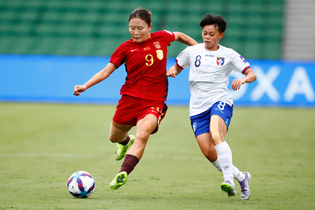 China's Wurigumula, left, and Taiwan's Li Yi-wen battle for the ball during the Women's Asian Cup quarterfinal soccer match between China and Taiwan in Perth, Australia, Saturday, March 14, 2026. (AP Photo/Gary Day)
