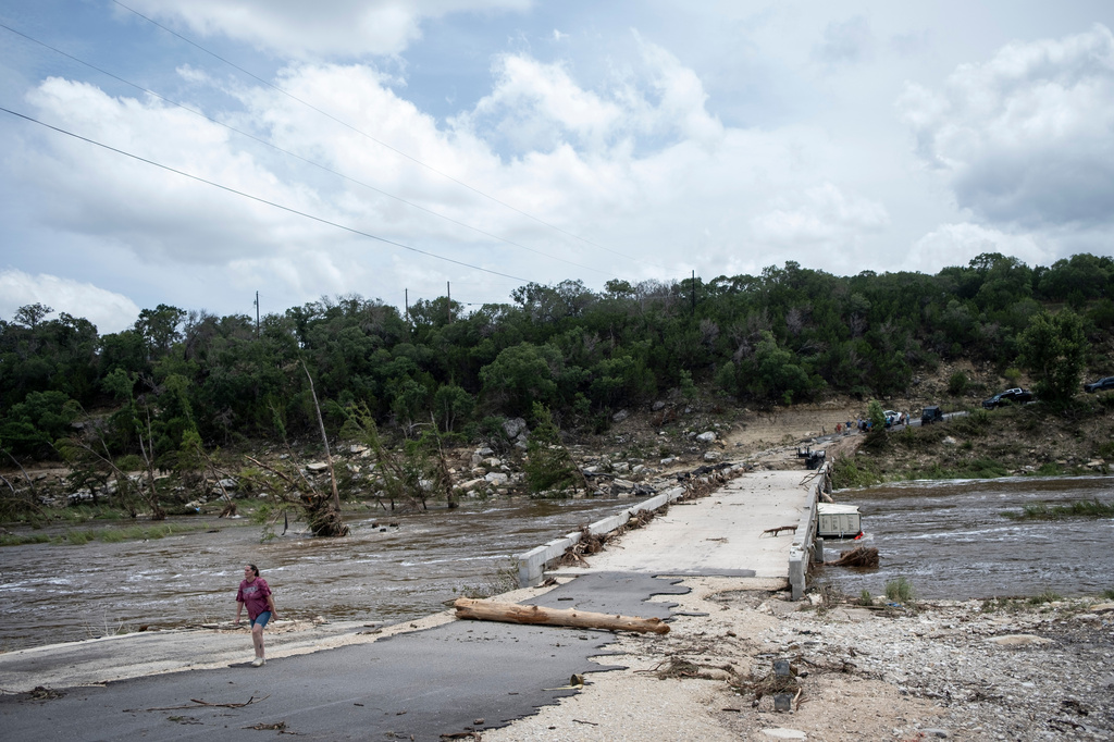 A person walks along the Guadalupe River after heavy floods on Friday, July 17, 2026, in Ingram, Texas. (AP Photo/Joel Angel Juarez)