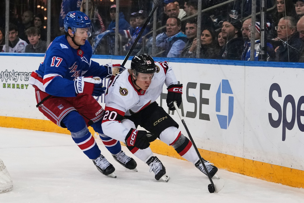 New York Rangers' Will Borgen (17) fights for control of the puck with Ottawa Senators' Fabian Zetterlund (20) during the first period of an NHL hockey game Monday, March 23, 2026, in New York. (AP Photo/Frank Franklin II)