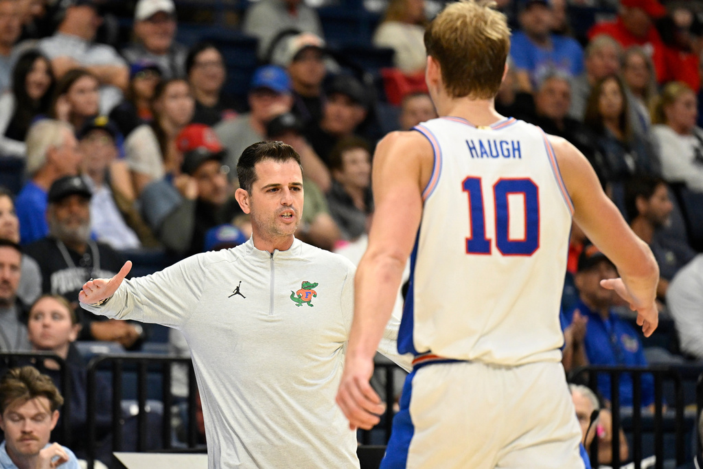 Florida head coach Todd Golden, left, congratulates Thomas Haugh (10) during the second half of an NCAA college basketball game against Providence in the Rady Children's Invitational tournament Friday, Nov. 28, 2025, in San Diego. (AP Photo/Denis Poroy)