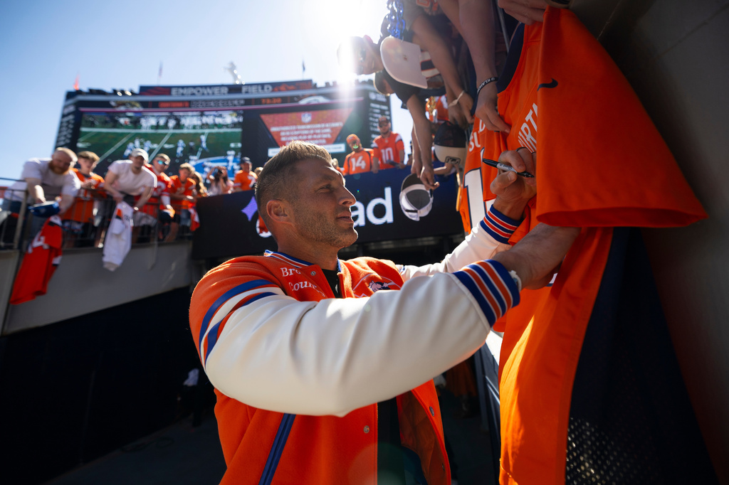 Tim Tebow signs autographs for Denver Broncos fans prior to an NFL football game against the Jacksonville Jaguars, Sunday, Sept. 20, 2026 in Denver. (Madilyn Gemme/Denver Broncos via AP)