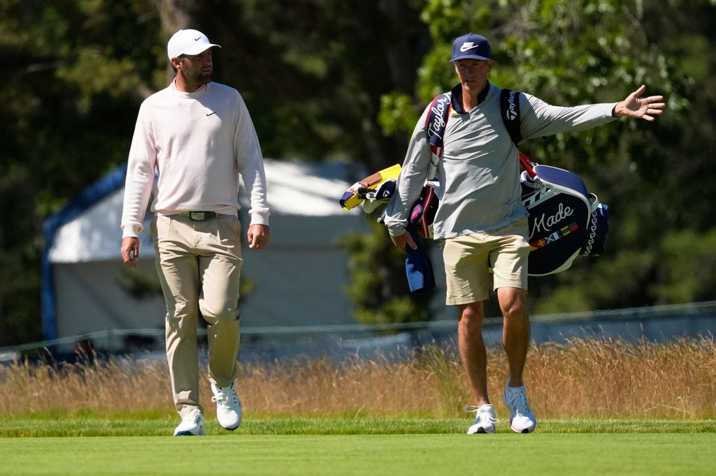 Scottie Scheffler talks with his caddie Ted Scott on the third hole during a practice round for the U.S. Open golf tournament at Shinnecock Hills Golf Club in Southampton, N.Y., Tuesday, June 16, 2026.(AP Photo/David J. Phillip)