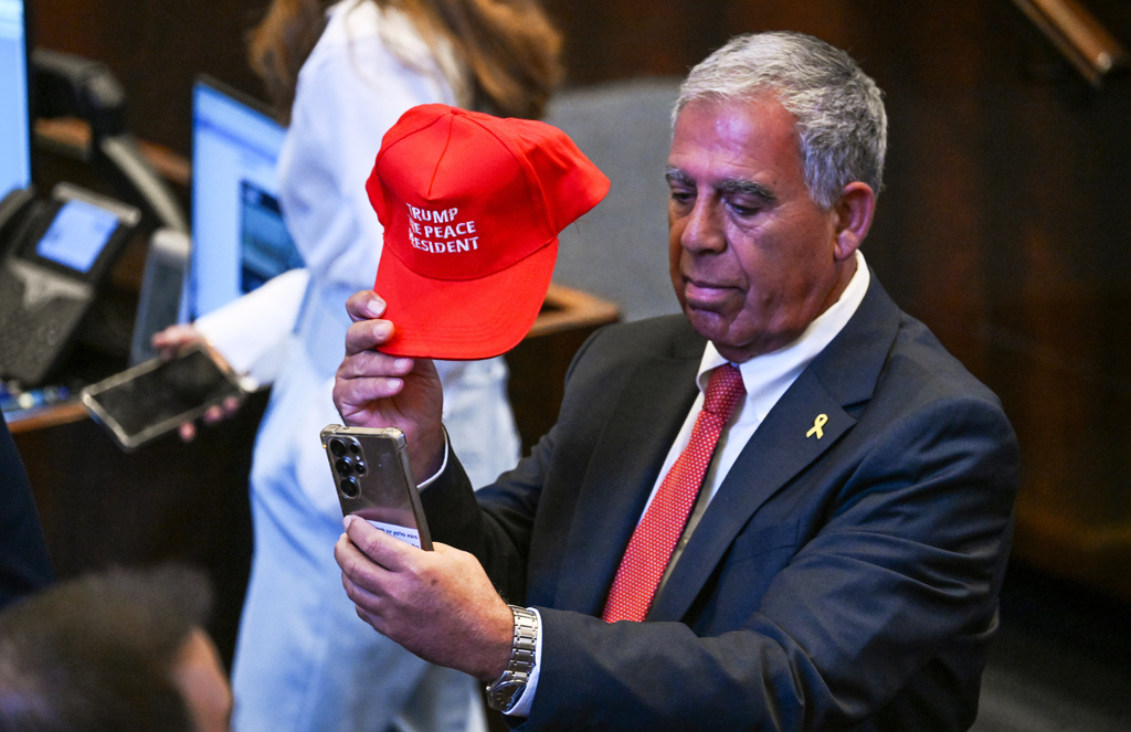 FILE - People wearing hats that read "Trump The Peace President" inside the Knesset as President Donald Trump prepares to deliver remarks, Oct. 13, 2025, in Jerusalem. (Kenny Holston/The New York Times via AP, Pool)