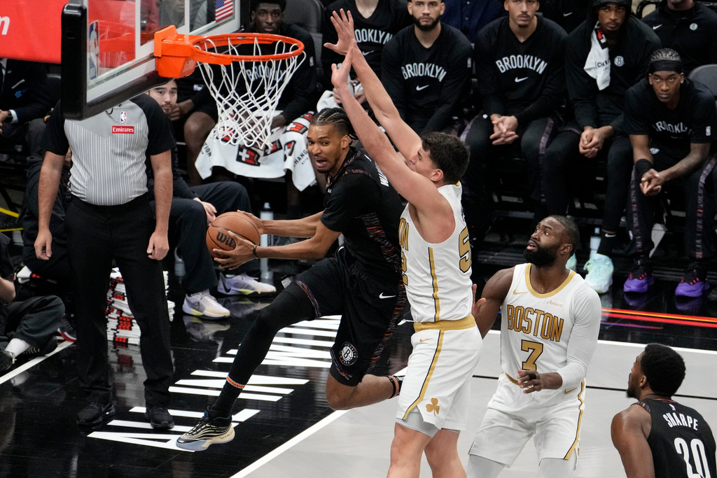 Brooklyn Nets forward Ziaire Williams, left, passes away the ball during the first half of an NBA basketball game against the Boston Celtics, Friday, Jan. 23, 2026, in New York. (AP Photo/Yuki Iwamura)