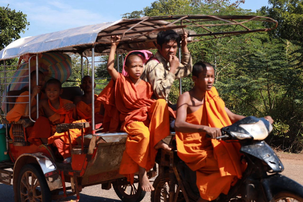 In this photo released by Agence Kampuchea Press (AKP), Cambodian Buddhist monks sit on a motor cart as they flee from their pagoda of Preah Vihear province, near the border with Thailand, Monday, Dec. 8, 2025. (AKP via AP)