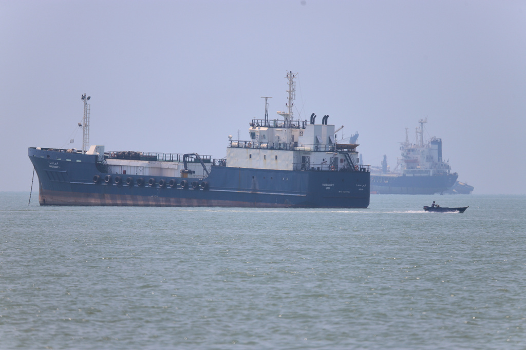 A small motorboat passes anchored vessels in the Strait of Hormuz off Bandar Abbas, Iran, Wednesday, June 17, 2026.(Amirhosein Khorgooi/ISNA via AP)