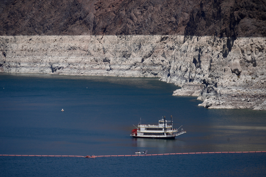 A paddle boat in Lake Mead near the Hoover Dam, far below the bathtub ring of light minerals indicating the lack of water, near Boulder City, Nev., on Friday, Aug. 7, 2026. (AP Photo/Ty ONeil)
