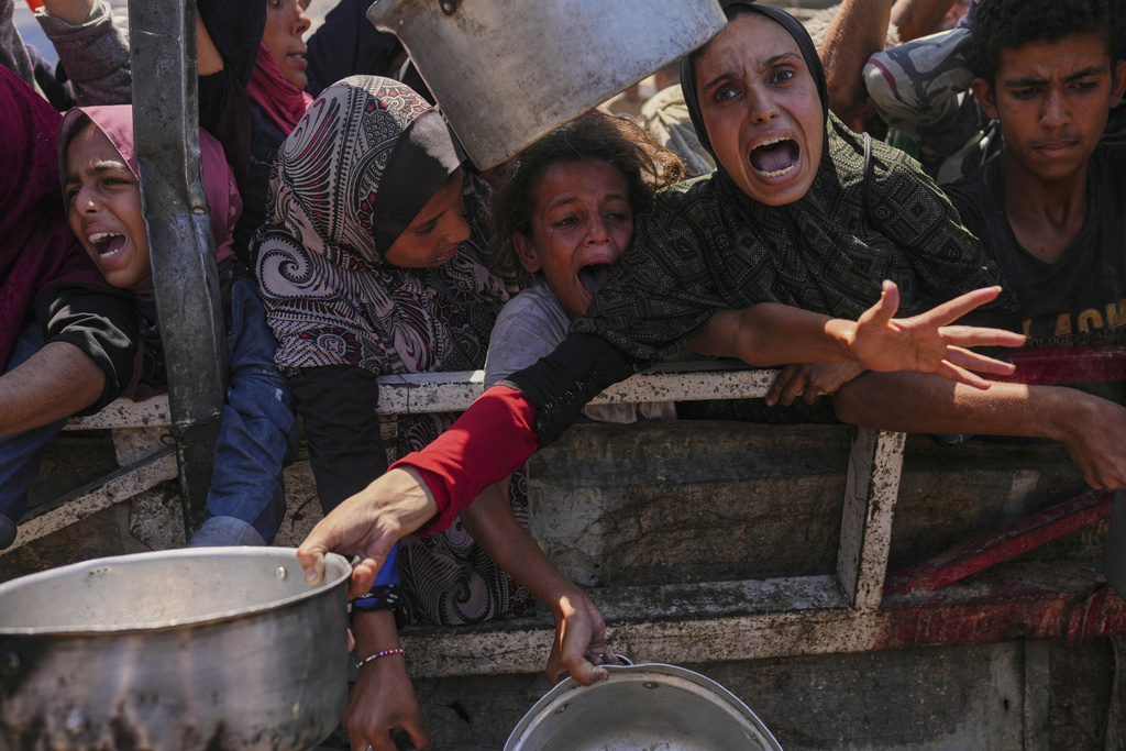 Palestinians struggle to get food at a community kitchen in Gaza City, northern Gaza Strip, Aug. 4, 2025. (AP Photo/Jehad Alshrafi)