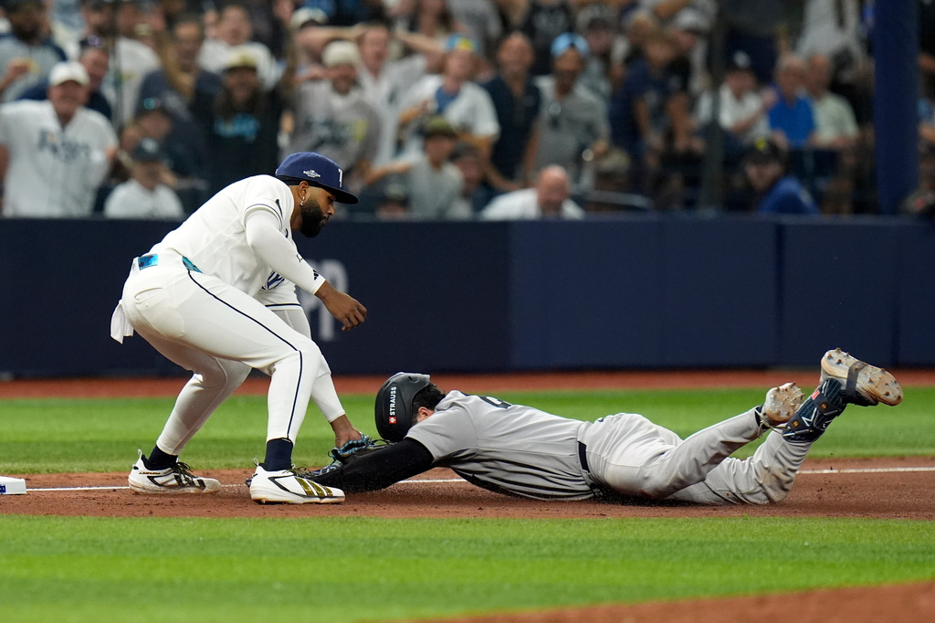 Tampa Bay Rays third baseman Junior Caminero, left, tags out New York Yankees' Austin Wells as Wells tries to stretch his double into a triple during the eighth inning of Game 1 of an American League Division Series baseball game Saturday, Oct. 3, 2026, in St. Petersburg, Fla. (AP Photo/Chris O'Meara)