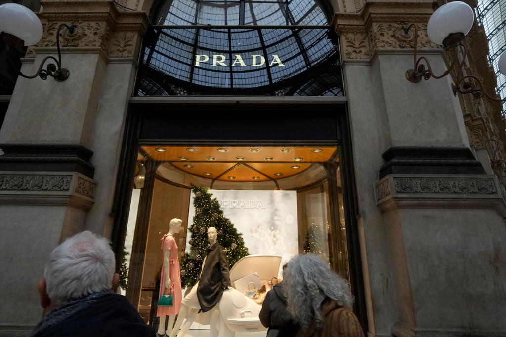 Customers look at a Prada shop window, in Milan, Italy, Tuesday, Dec. 2, 2025. (AP Photo/Luca Bruno)