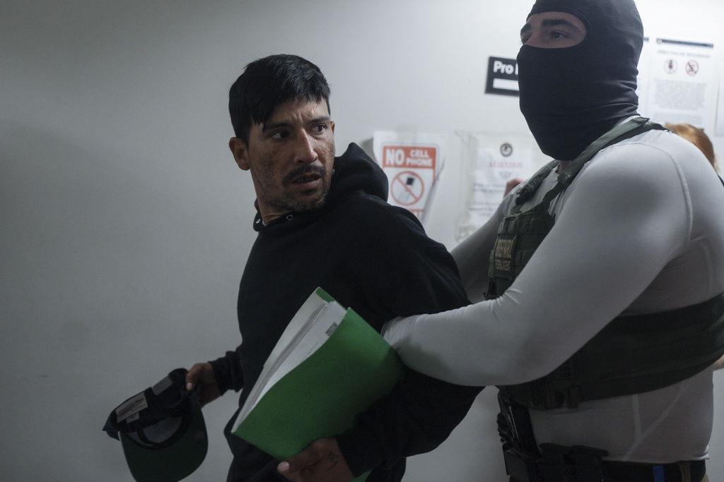 Marlon Garcia, an asylum seeker from Ecuador, turns to look back at his wife and children as he is detained after the conclusion of his immigration hearing, Thursday, July 3, 2025, in New York. (AP Photo/Olga Fedorova)