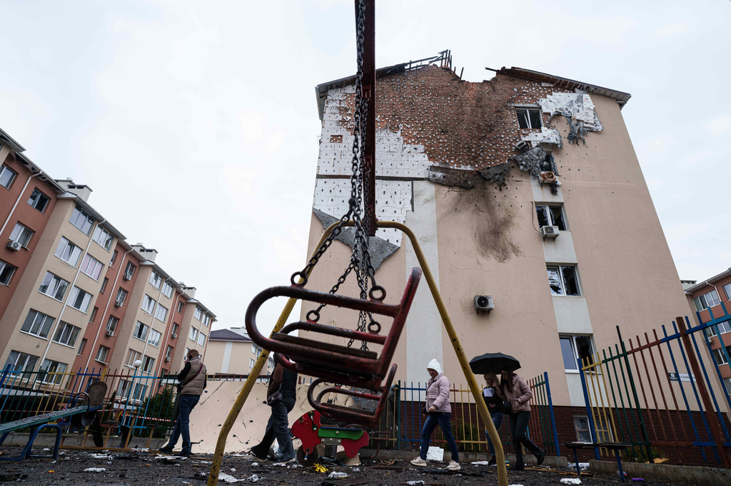 People walk in front of a house which was damaged after a Russian strike on residential neighbourhood in Kriukivshchyna, Kyiv region, Ukraine, on Friday, April 3, 2026. (AP Photo/Evgeniy Maloletka)